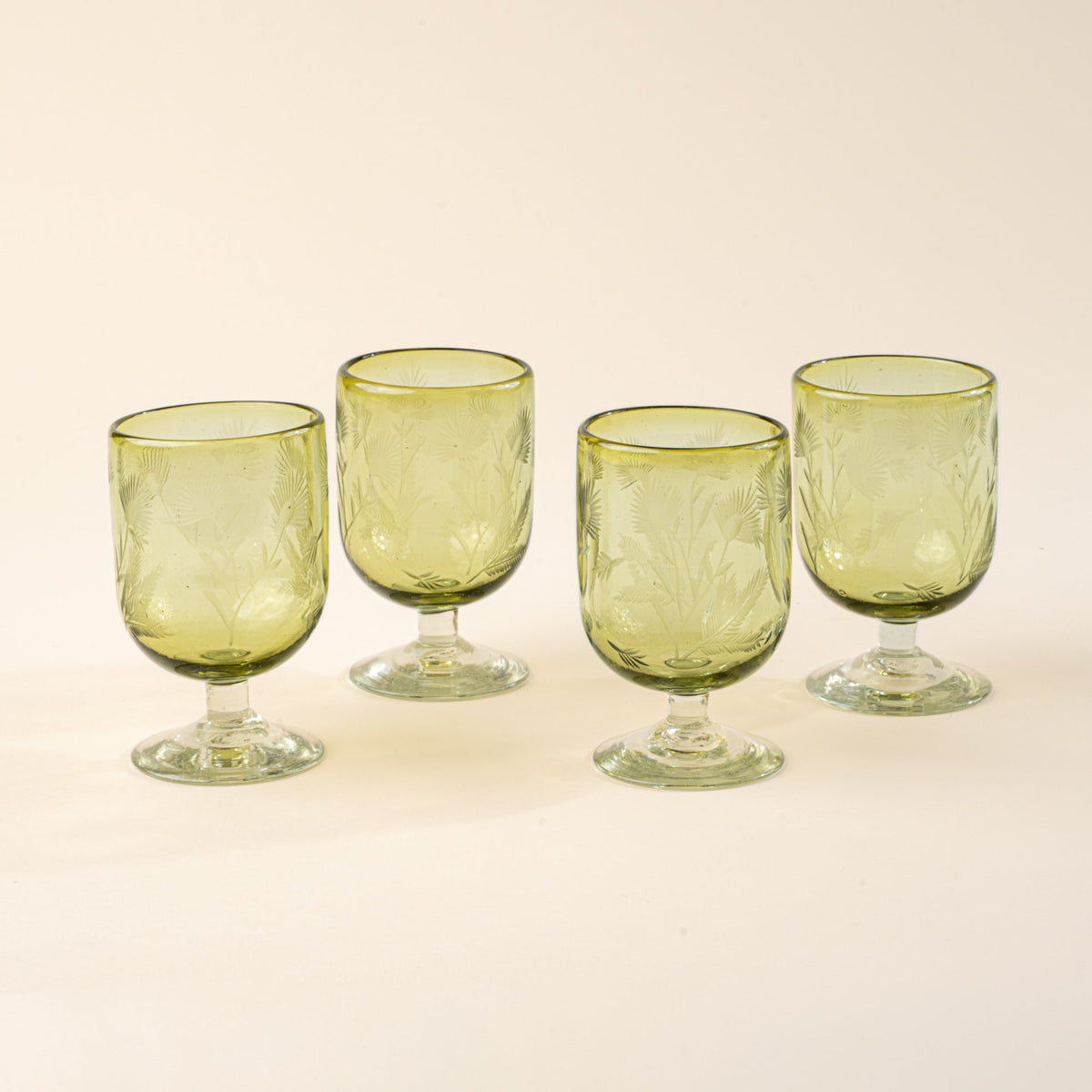 Four olive short wine glasses made of recycled glass with etched thistle designs on it