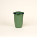 A tall green enamel tumbler with a dark rim, set against a soft beige background.